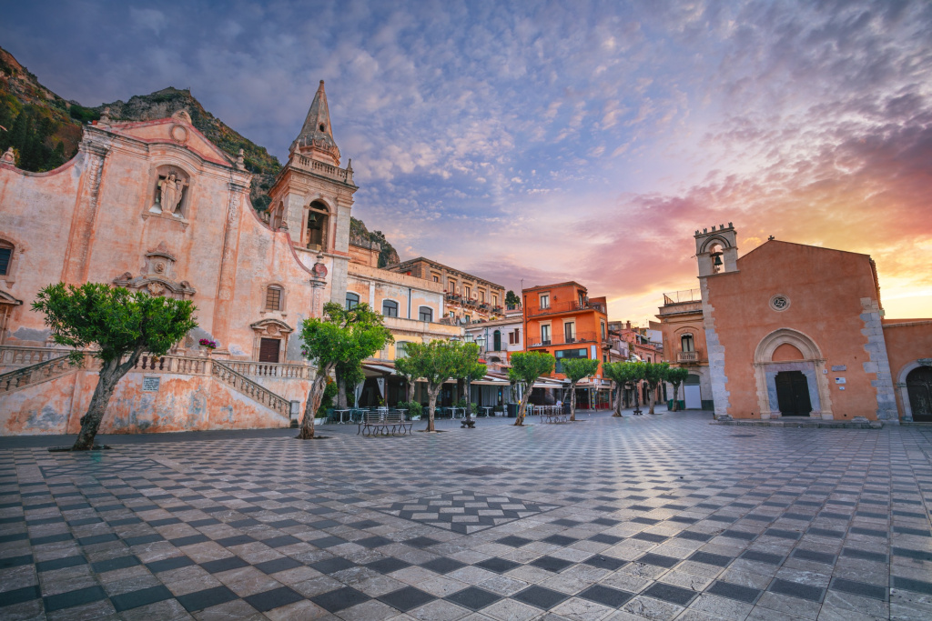Городской пейзаж живописного города Таормина, Сицилия с главной площадью Пьяцца IX Априле и церковью Сан-Джузеппе на рассвете