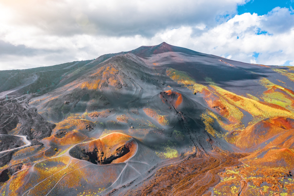 Вид на действующий вулкан Этна, потухшие кратеры на склоне, следы вулканической деятельности