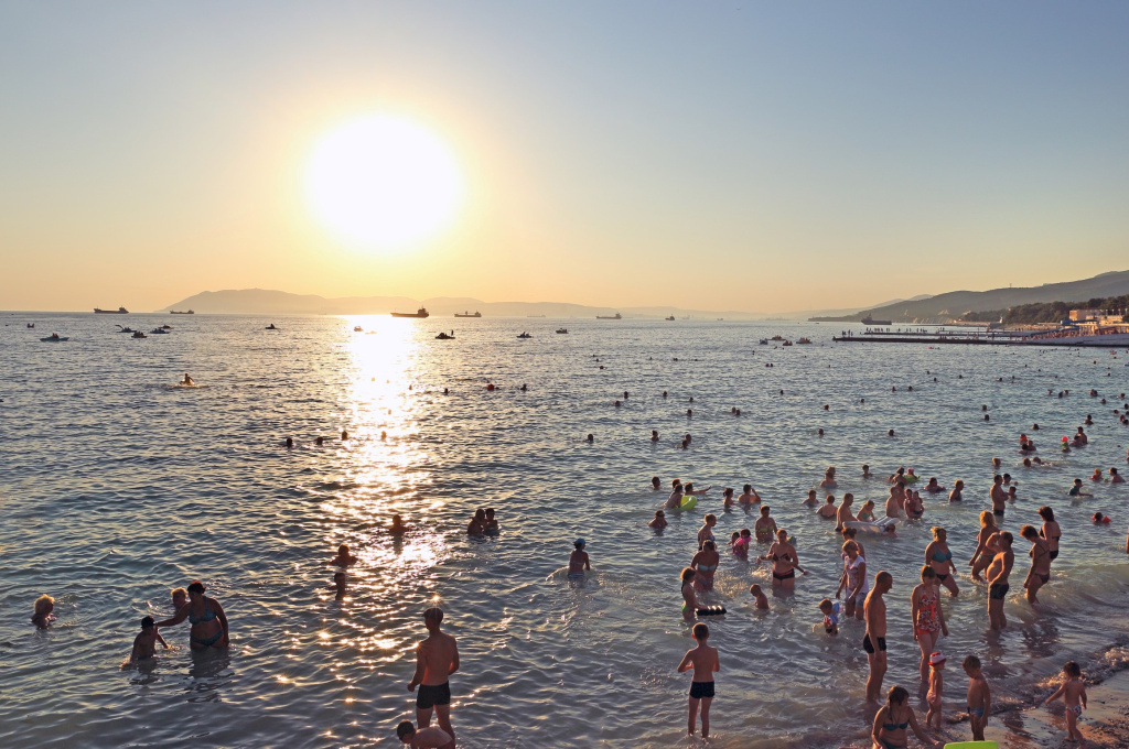 Многочисленные туристы отдыхают на пляже Мысхако на закате