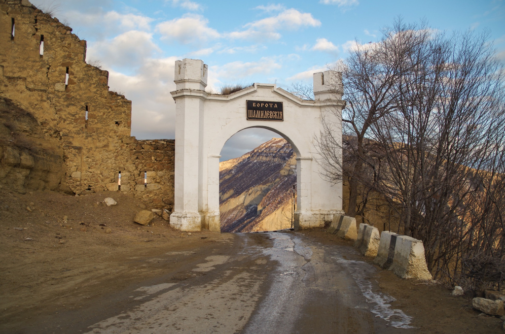 Живописный вид на пустую дорогу, ворота Шамиля и оборонительную стену вечером, Дагестан