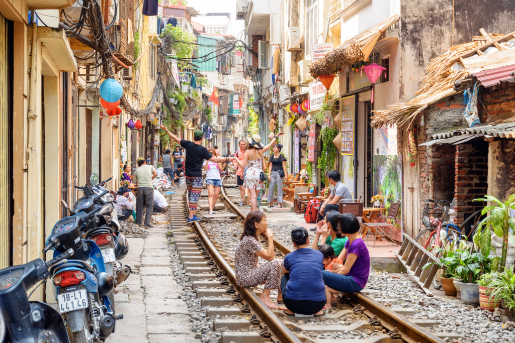 Жители и туристы отдыхают на железнодорожной улице Ханоя перед очередным проездом поезда, Вьетнам