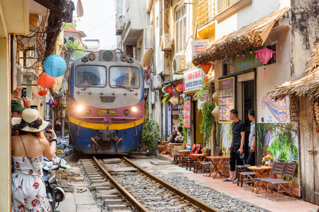 Невероятный вид на поезд, проходящий по узкой улочке Старого квартала Ханоя